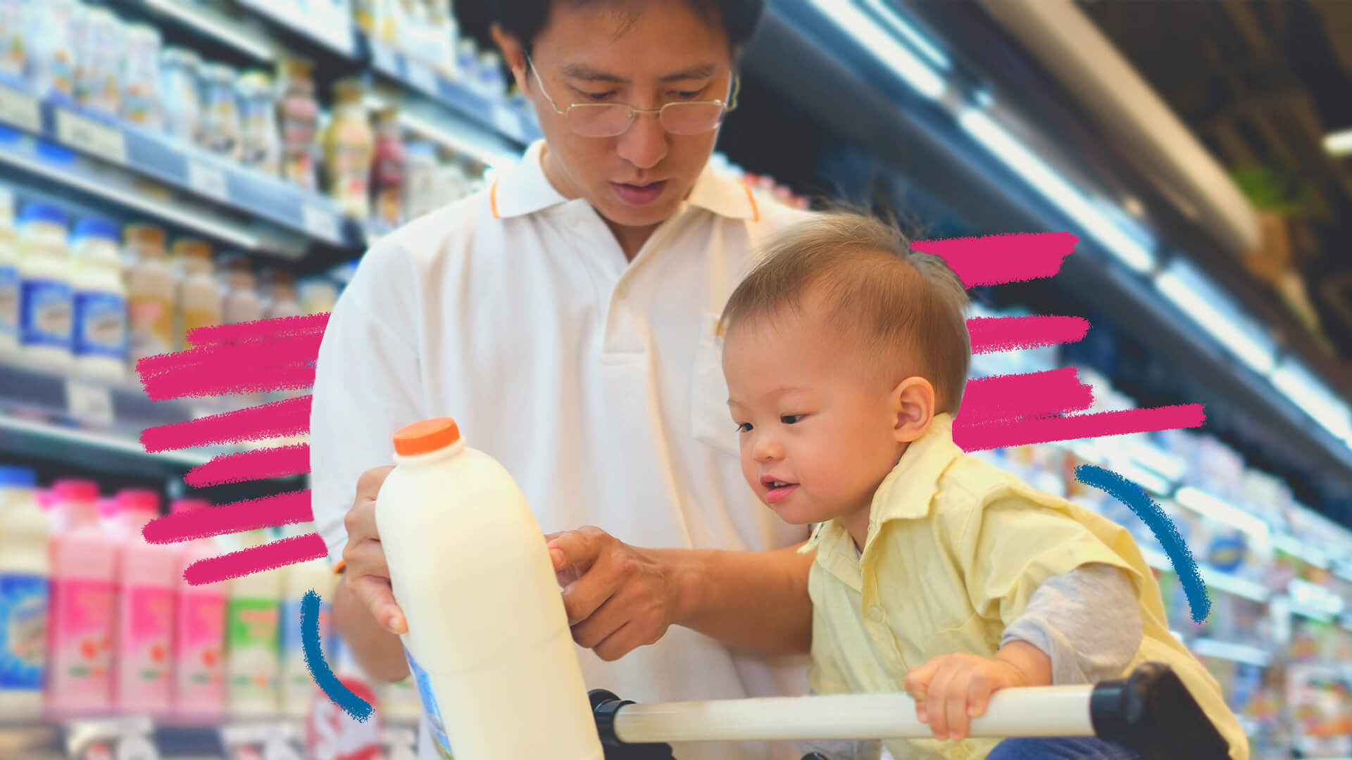 Um homem asiático está com uma garrafa de leite nas mãos. Ao lado, uma criança asiática, em cima de um carrinho de supermercado observa o objeto; nas prateleiras outros produtos lácteos da seção.