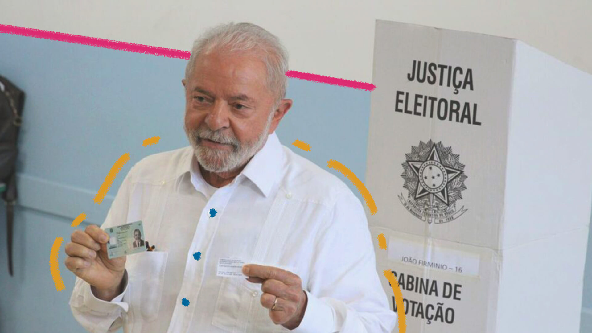 A imagem mostra Luiz Inácio Lula da Silva, um homem branco, idoso, com barba e cabelos brancos. Ele veste uma camisa branca, segura nas mãos um comprovante de eleição e sua habilitação para dirigir.