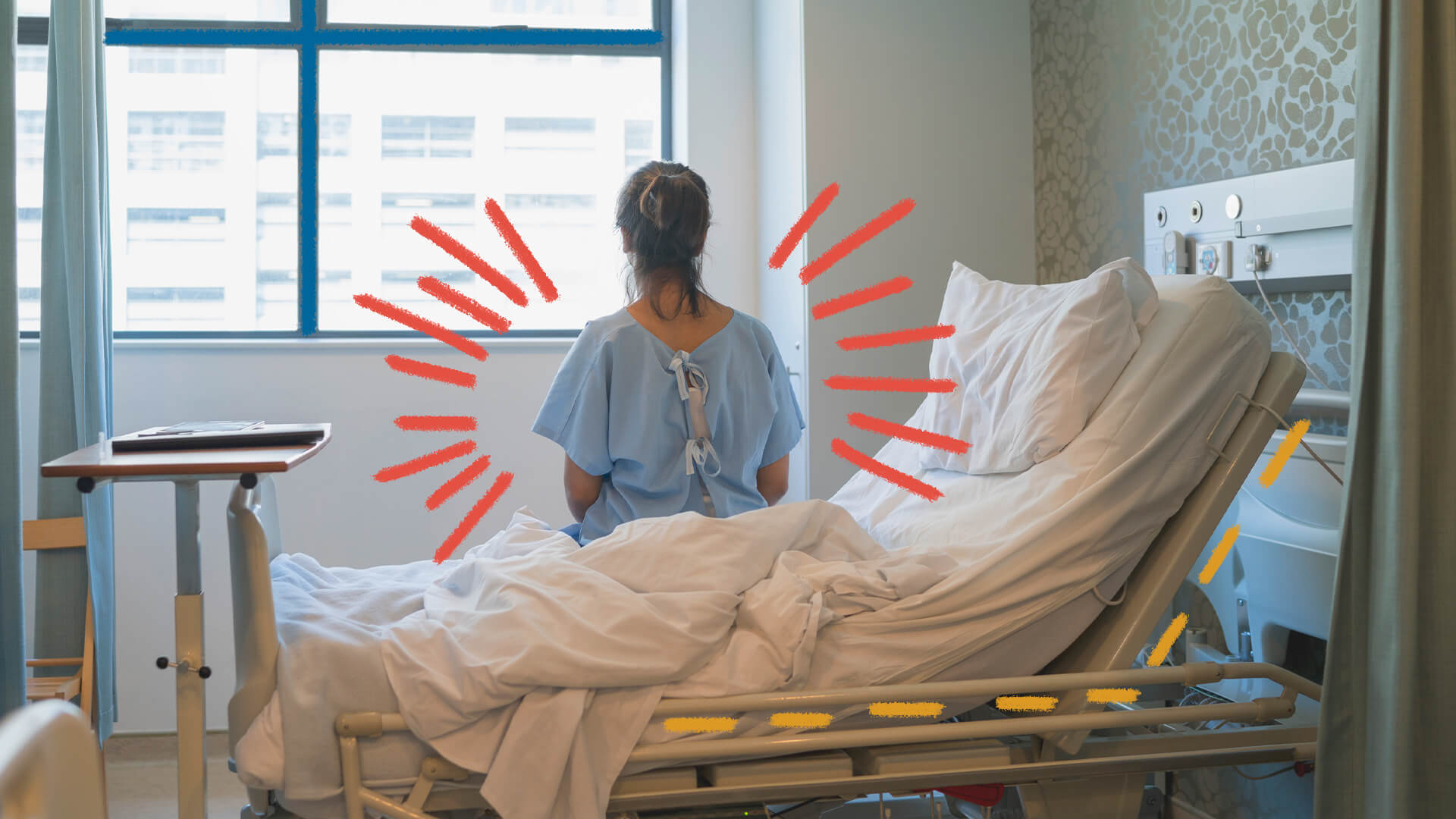 Uma mulher está sentada de costas, olhando para uma janela, em um leito de hospital.