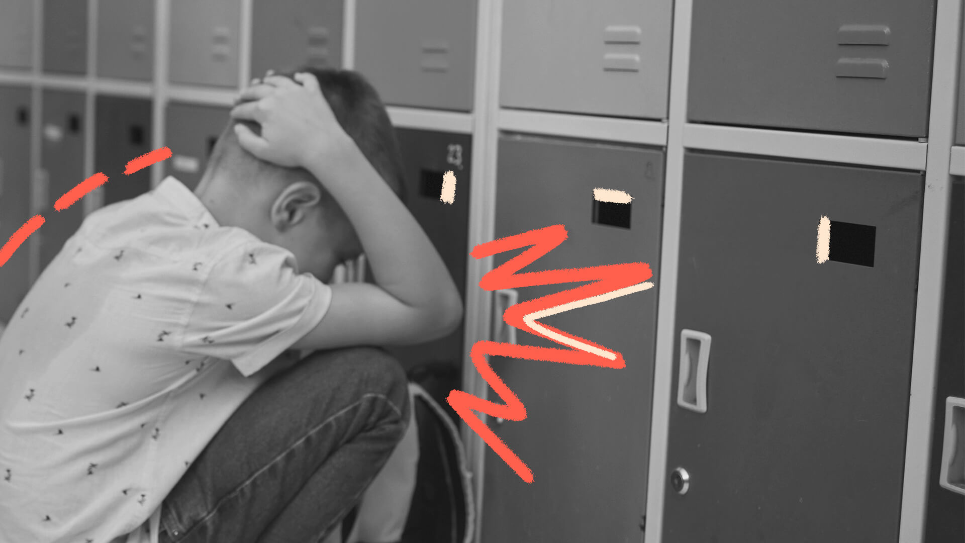 Imagem em preto e branco de um menino protegendo a cabeça. Ele está agachado na frente de armários escolares.