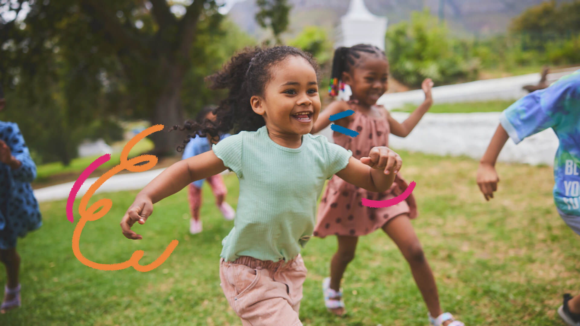 Crianças negras sorriem enquanto correm em um ambiente aberto.