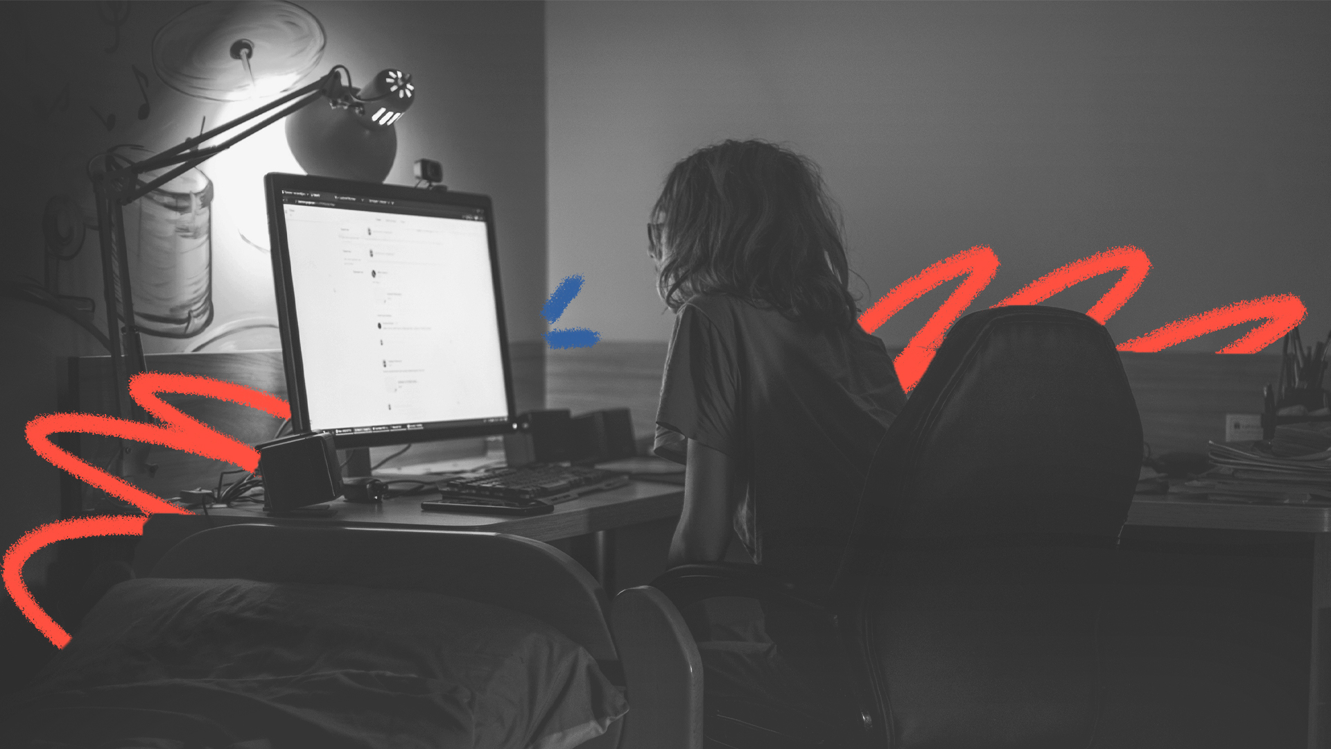 Imagem em preto e branco de um menino branco, de cabelos no ombro, que olha para a tela de um computador. A foto ilustra matéria sobre ataques em escolas.