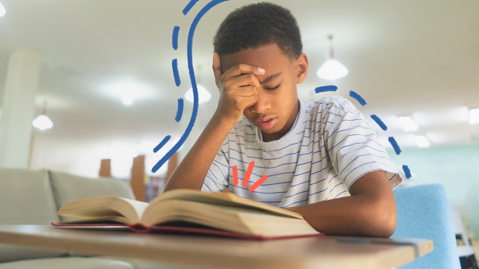 Um menino negro está com a mão na testa enquanto lê um livro apoiado na mesa
