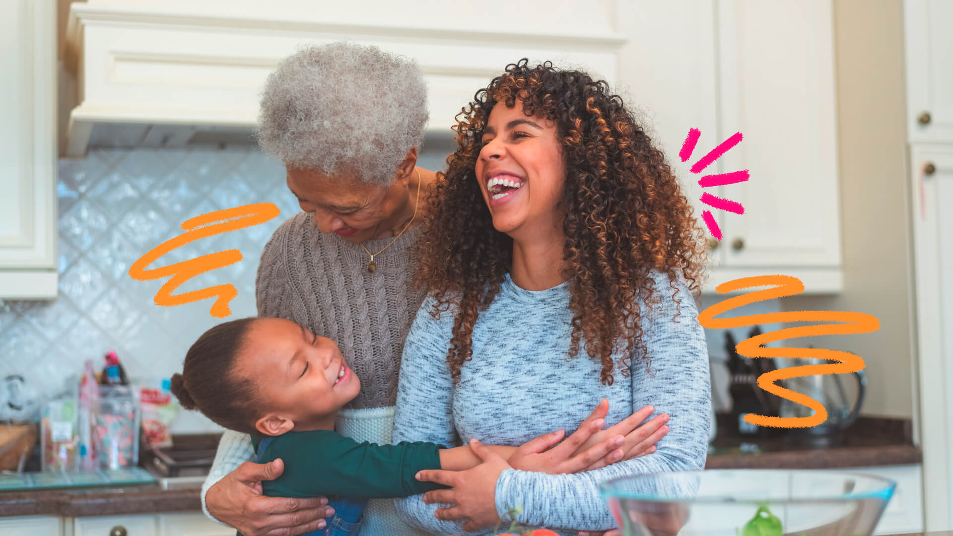 Foto de três mulheres de três gerações diferentes, avó, mãe e filha. Todas são negras e estão se abraçando e sorrindo