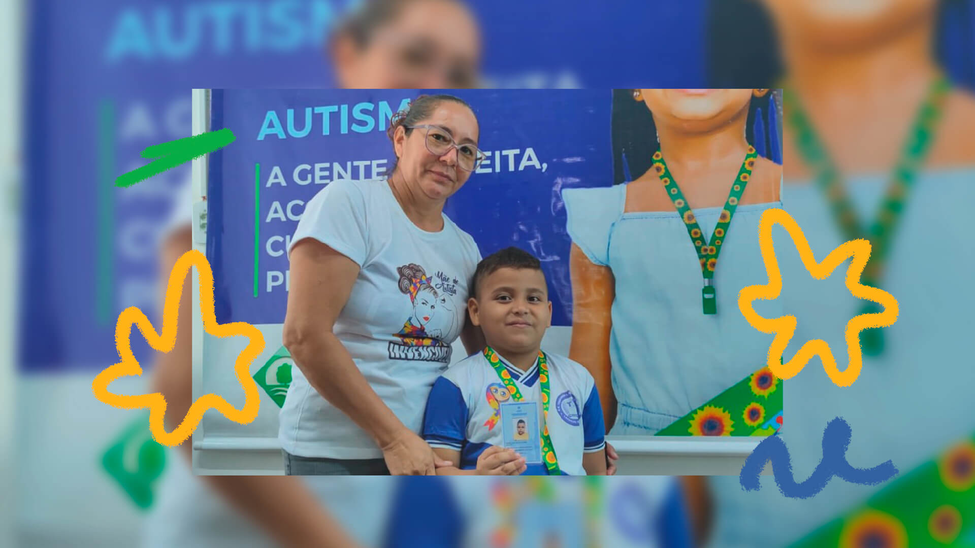 Mulher branca de óculos e cabelos presos posa ao lado de menino branco usando o cordão de fita de girassóis e carteirinha.