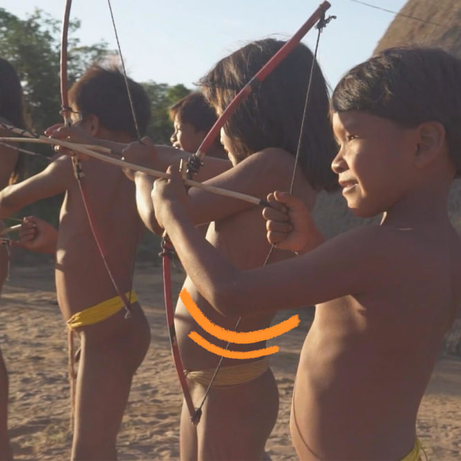 quatro crianças indíegas estão em pé brincando de arco e flecha