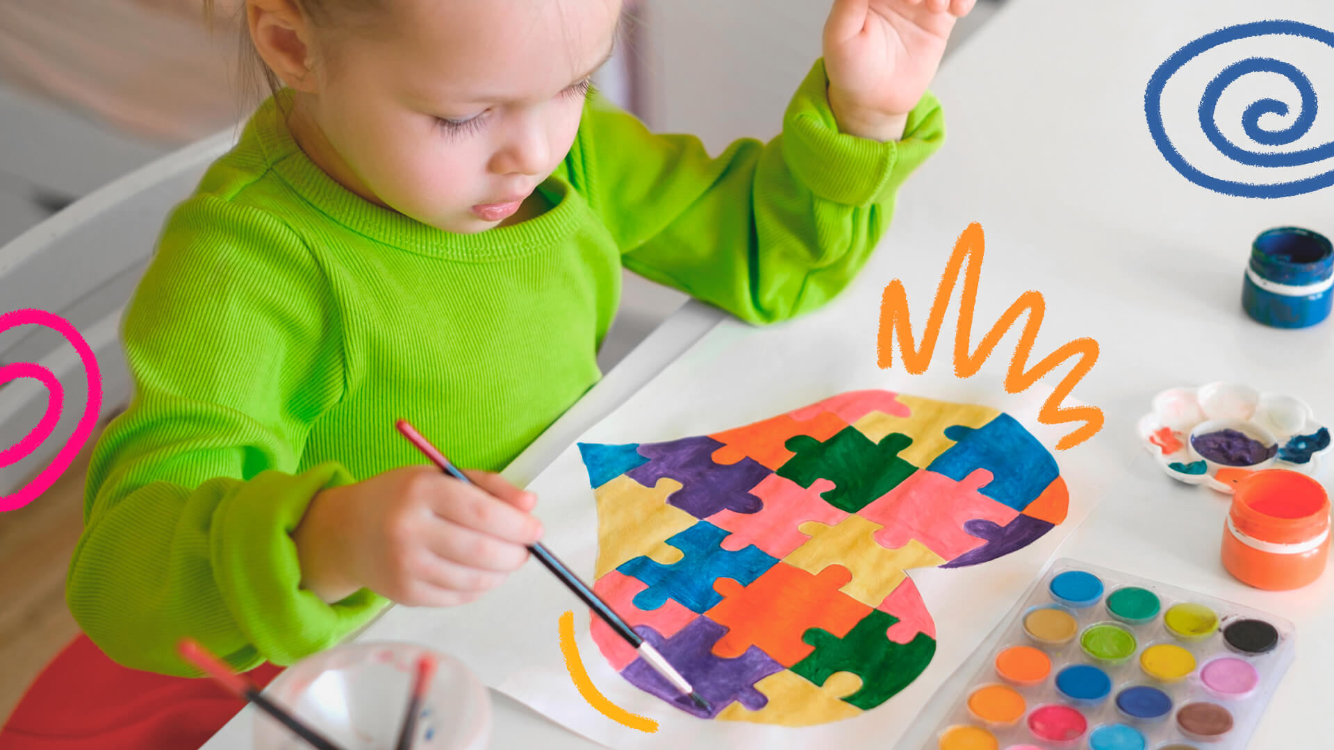 Uma criança branca pinsa um quadro com peças de quebra-cabeça, símbolo do espectro autista.