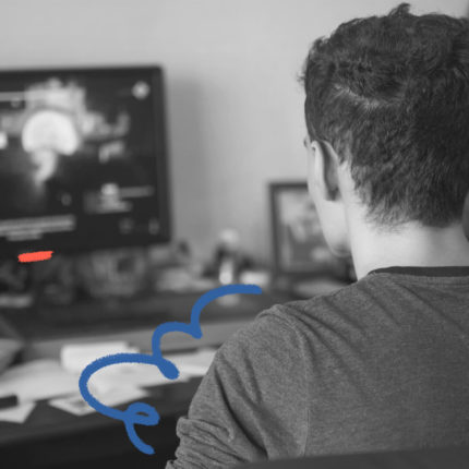 Foto em preto e branco de um jovem de costas sentado em frente a um computador. A matéria é sobre a geração do quarto