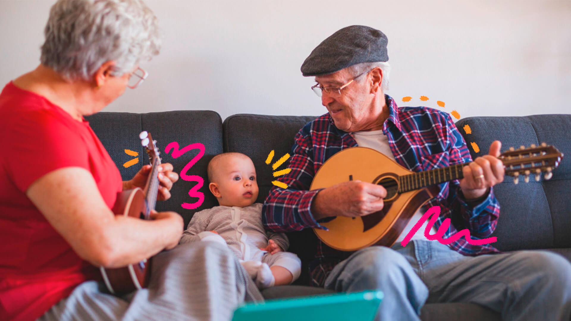 Na imagem, um homem idoso e um bebê, avô e neto, estão sentados um ao lado do outro em um sofá. O avô toca um instrumento de cordas e sorri para o neto. Ambos possuem pele branca.