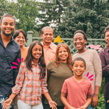 Família com nove pessoas posa para a foto sorridentes. entre crianças, jovens, adultos e idosos, a fam[ilia representa a geração sanduíche.