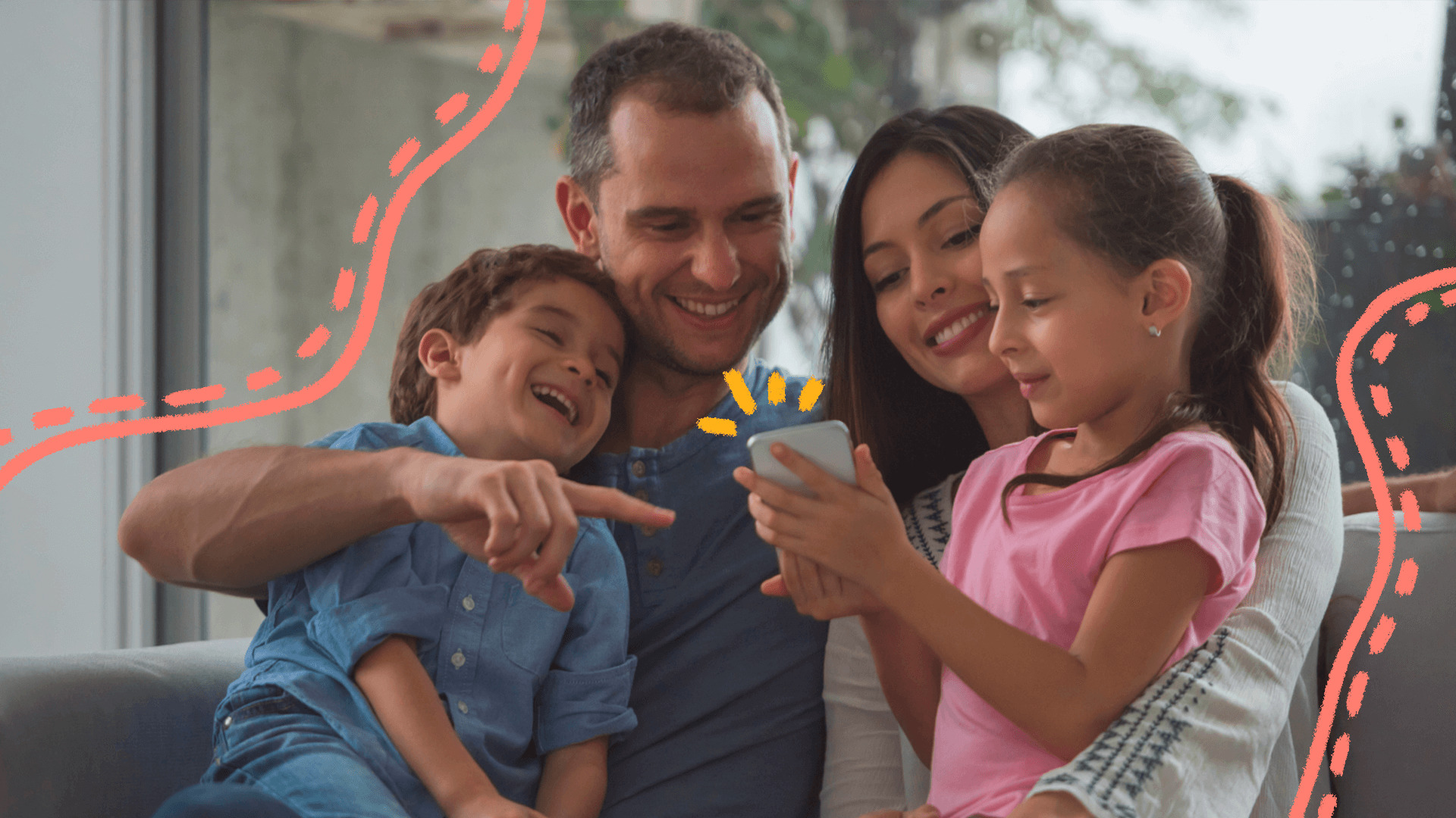 Foto de um casal com os dois filhos olhando para um celular. Quem segura o aparelho é a menina, que usa camiseta rosa.