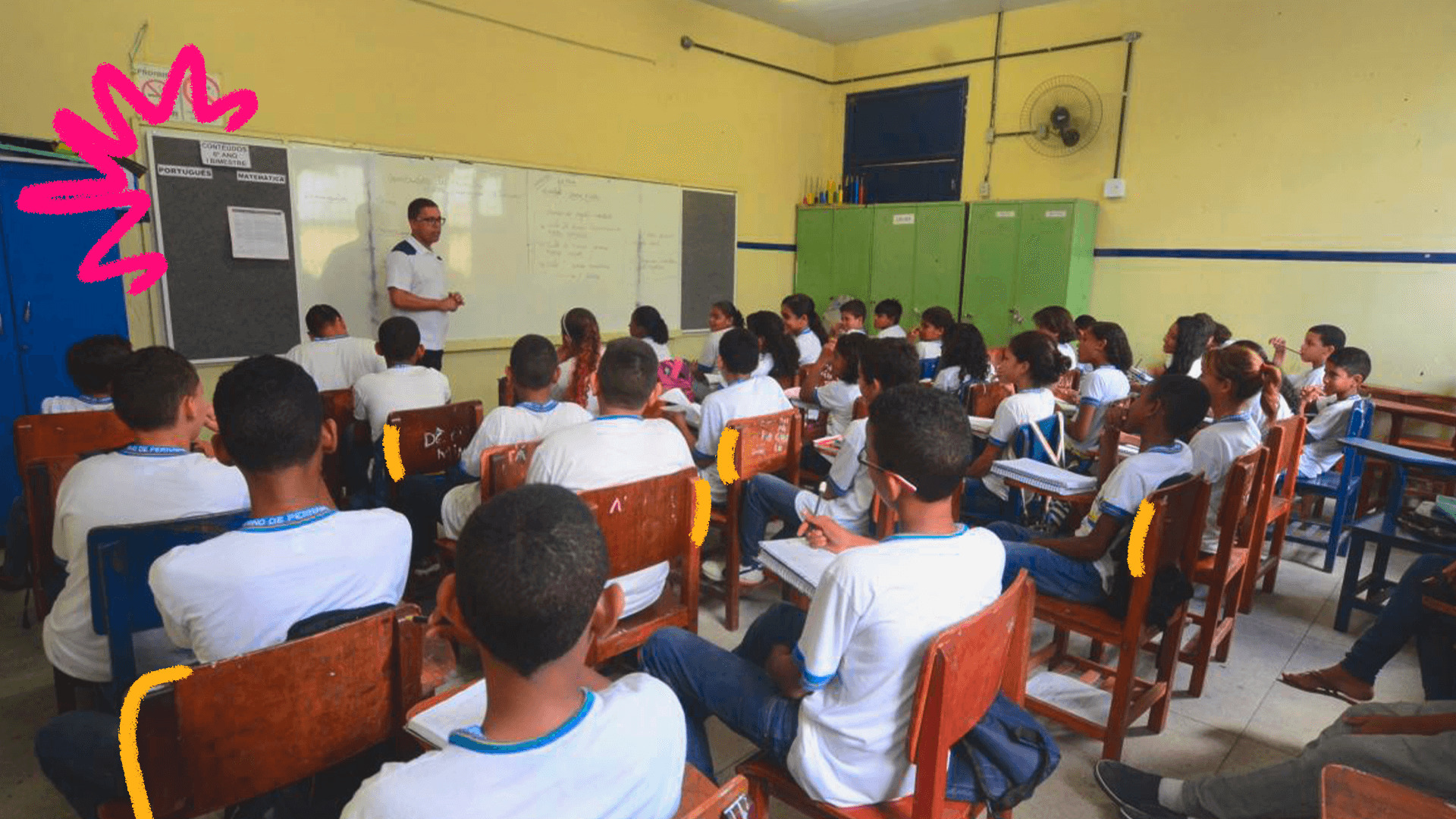 Imagem ilustra matéria sobre programa de bolsa para o ensino médio msotra uma sala de aula cheia de alunos adolescentes virados de costas, olhando para a lousa.