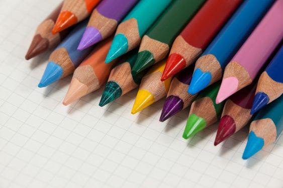 Lápis de cor coloridos em cima de papel.