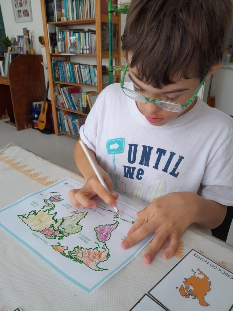 Menino pintando um mapa-múndi.