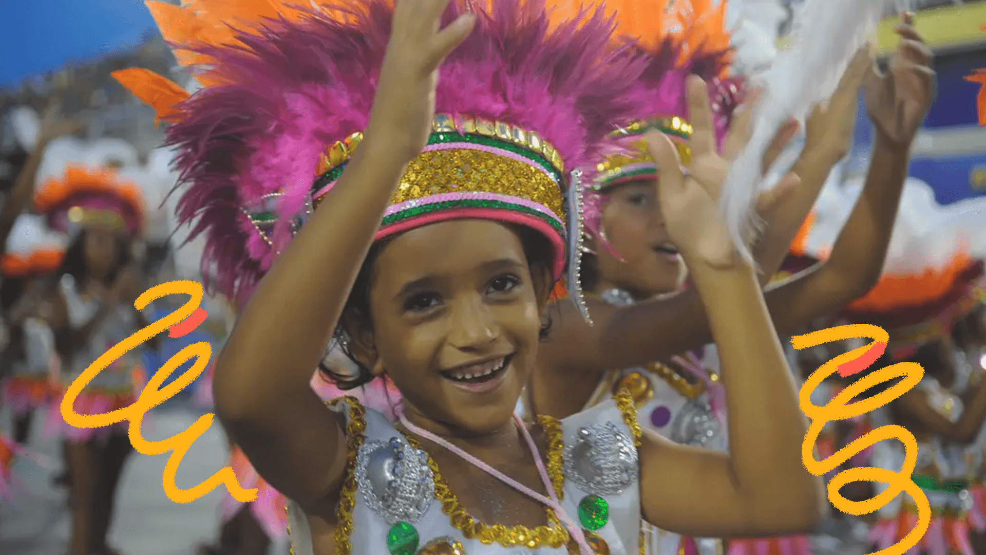 imagem mostra crianças no carnaval e o destaque de um menino negro com fantasia e adereço na cabeça.
