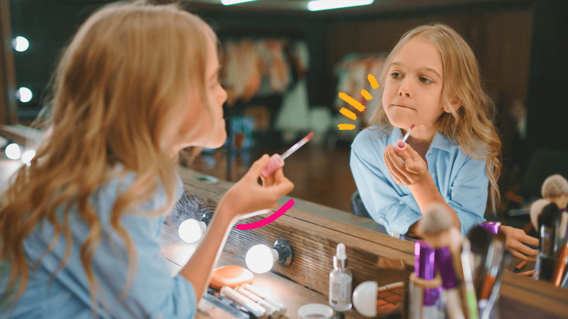 Imagem de capa para matéria sobre maquiagem para crianças mostra uma menina loira de cabelos longos passando batom diante do espelho, em uma penteadeira com outros produtos na mesa.
