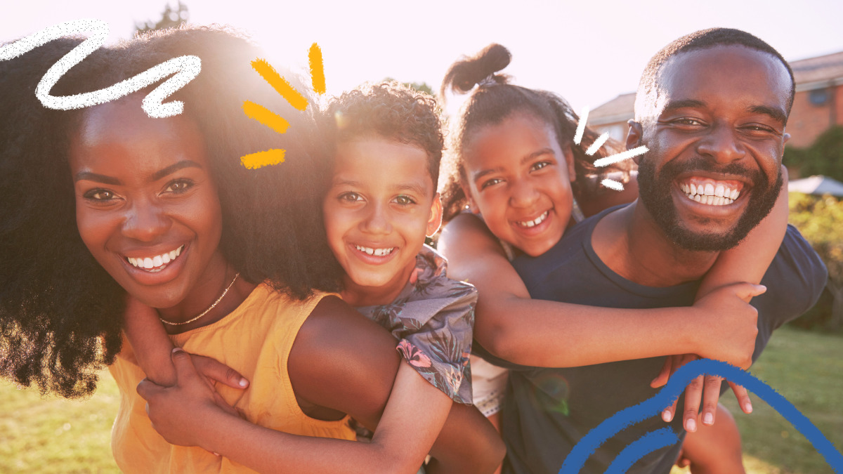Imagem de uma familia de pessoas negras com dois filhos, um menino e uma menina. Todos usam roupas coloridas e estão se abraçando e sorrindo. A matéria é sobre a lei de parentalidade positiva e direito ao brincar.
