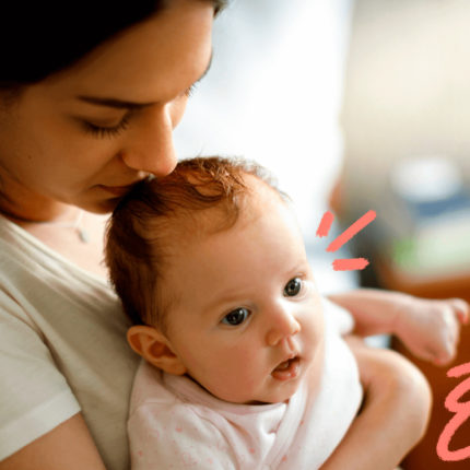 Imagem de capa para matéria que discute algumas frases sobre maternidade mostra uma mulher branca, de cabelos presos, sentada com um bebê pequeno no colo e beijando a cabeça da criança.