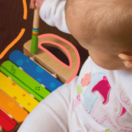 imagem para matéria sobre a lei da atenção precoce mostra um bebê visto de cima brincando com um brinquedo colorido e sensorial