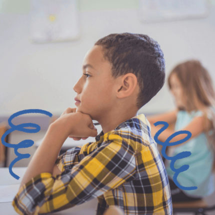 Matéria sobre o Pisa 2022 tem a imagem de uma sala de aula e o destaque para um menino pardo vestindo camisa xadrez sentado na carteira
