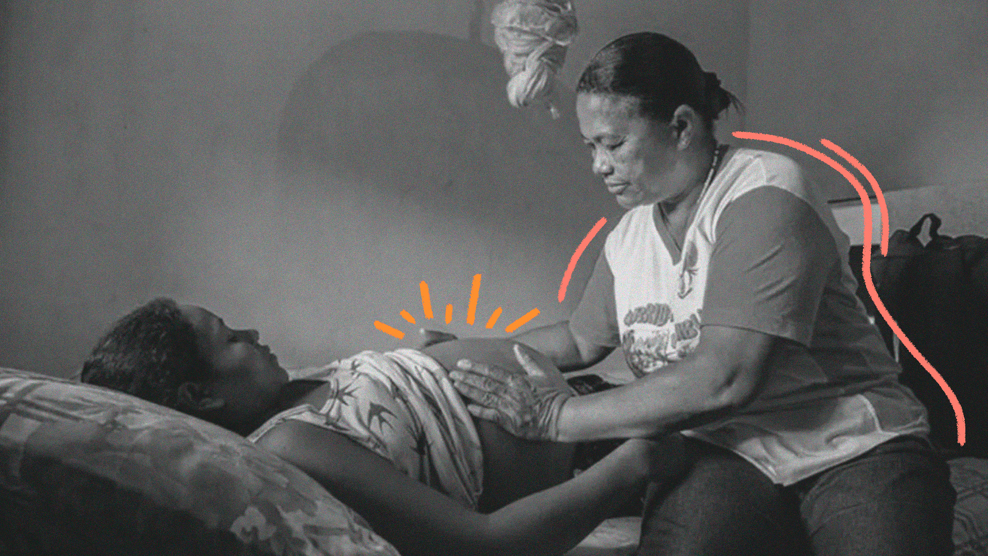 imagem para matéria sobre parteiras tradicionais mostra uma mulher mais velha sentada em uma cama tocando na barriga de uma mulher grávida que está deitada.