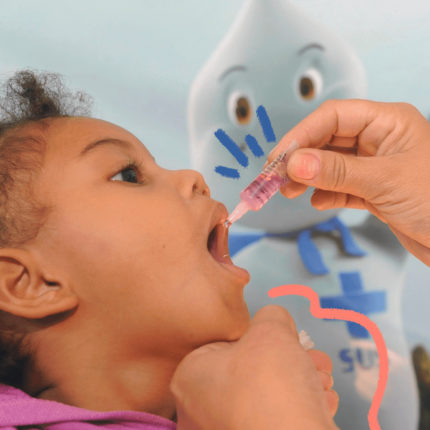 imagem de capa para matéria sobre adultos que viveram com a poliomielite mostra uma criança, menina, negra, de cabels cacheados, recebendo vacina oral.