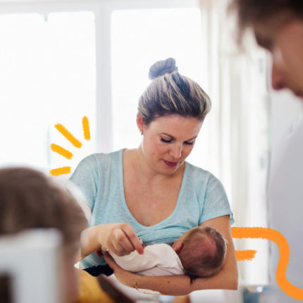 imagem de capa para matéria sobre amamentação mostra uma mulher branca amamentando um bebê e sendo observada por um home e uma criança