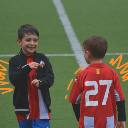 Imagem de capa para matéria sobre atletas mirins mostra dois meninos brancos vestindo uniforme de time de futebol e sorrindo dentro de um campo