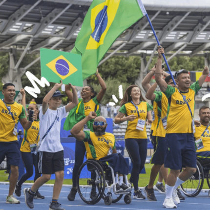 Imagem de capa de matéria sobre Paralimpíadas mostra uma foto de atletas paralímpicos da delegação brasileira vestindo roupas verde e amarela e comemorando em um estádio