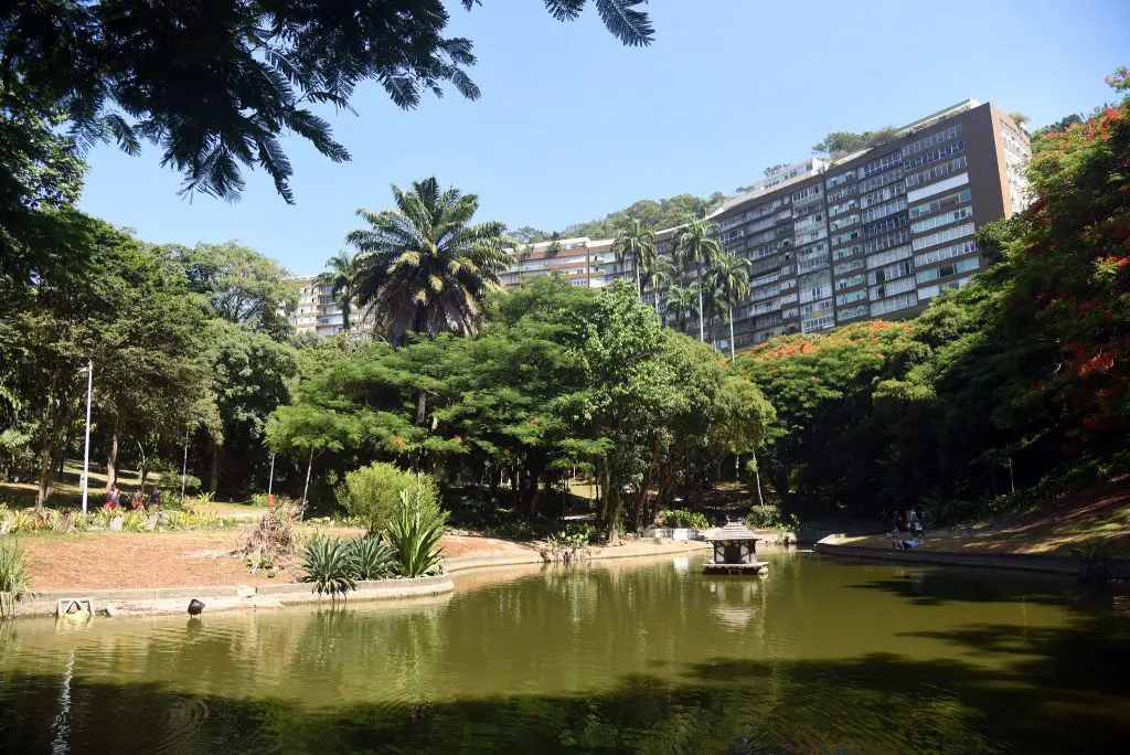 Imagem de parques inclusivos mostra o parque Guinle, um aárea verde com lago no centro, árvores em volta e espaços para caminhada. 