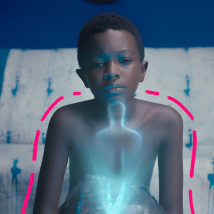 Imagem de capa para matéria sobre afrofuturismo mostra um acena do filme Mepai e a praia, em que um menino negro está sentado no so fá de casa e observa um holograma.