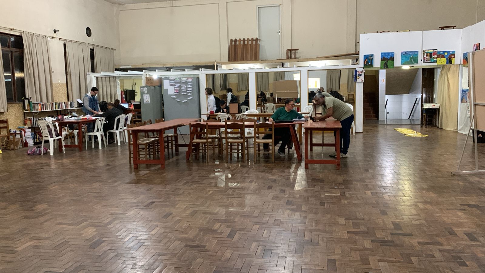 Imagem mostra alunos assistindo aulas em um salão de uma igreja.