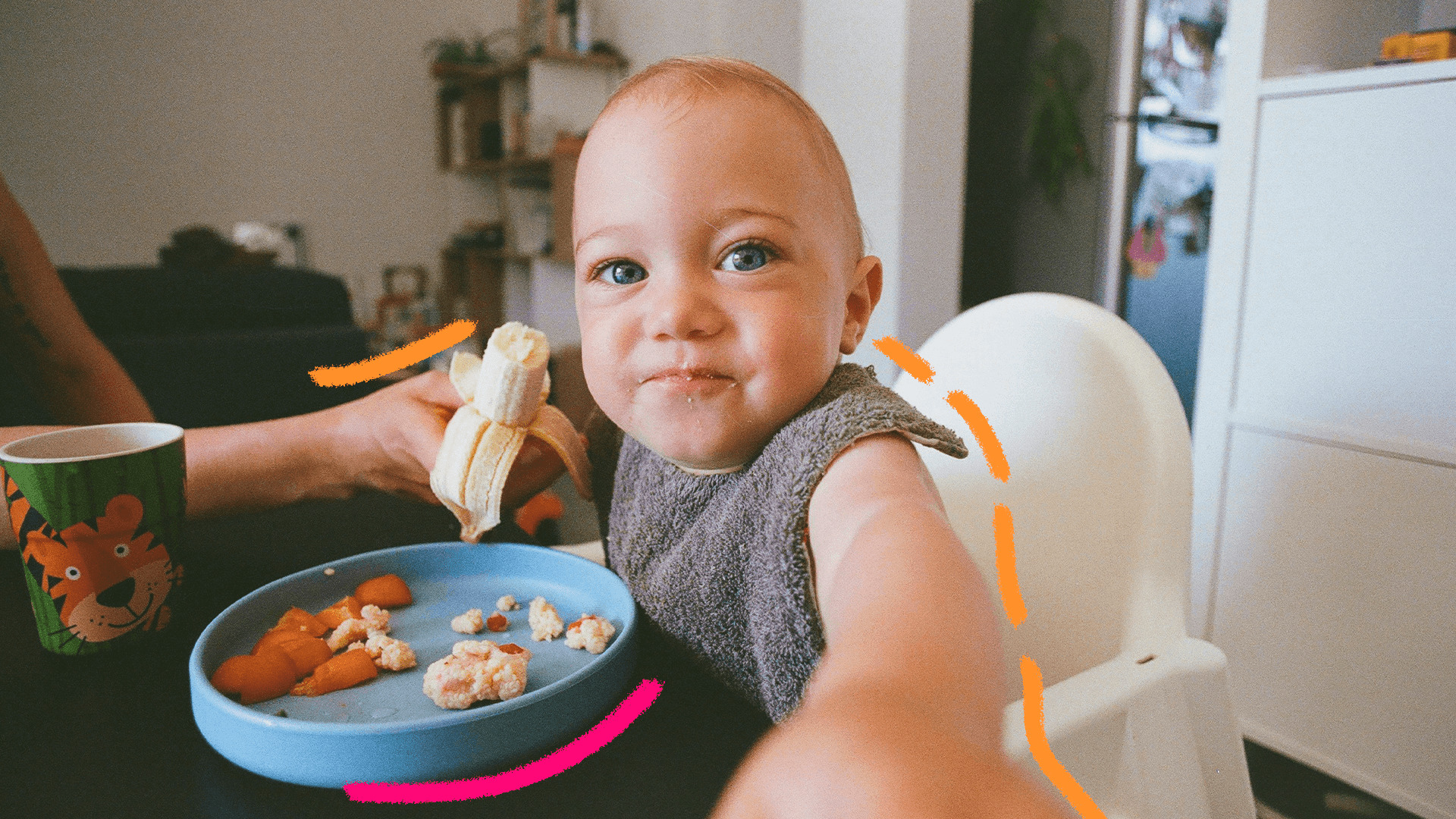 Imagem de capa mostra um bebê branco, sentado em um cadeirão de alimentação e comendo uma banana.