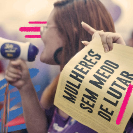 Imagem de capa para matéria sobre mulheres na política mostra uma foto de uma mulher branca de lado falando em um megafone e segurando uma placa escrito 'mulheres se medo'.