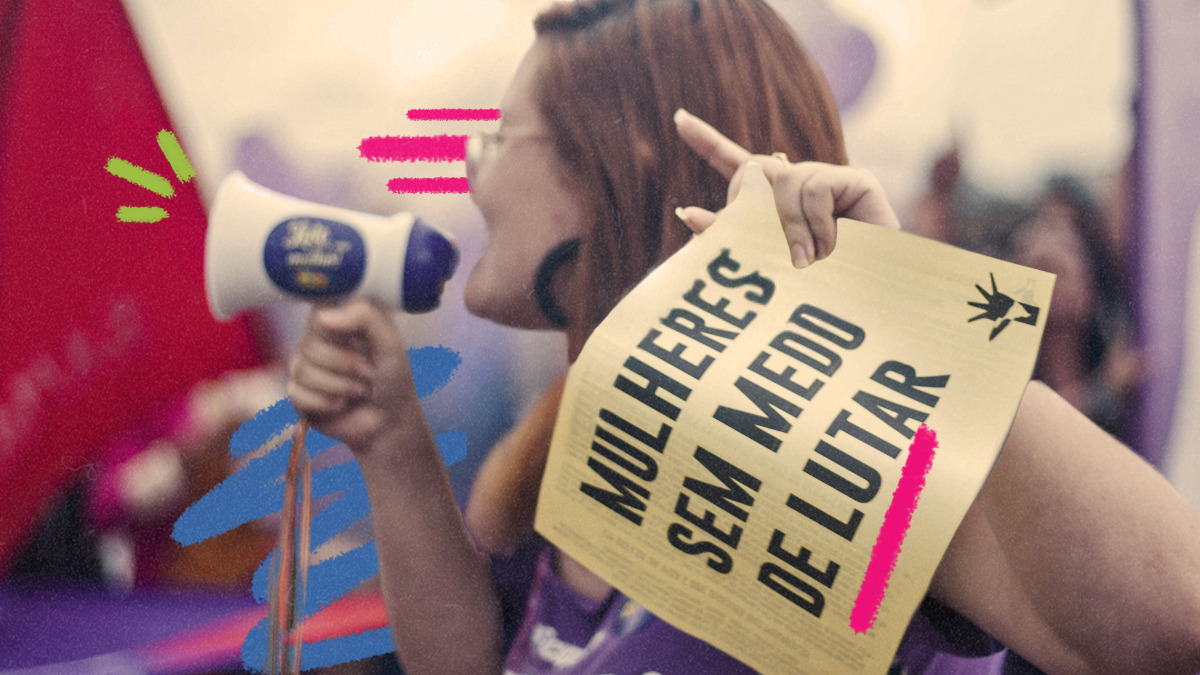 Imagem de capa para matéria sobre mulheres na política mostra uma foto de uma mulher branca de lado falando em um megafone e segurando uma placa escrito 'mulheres se medo'.