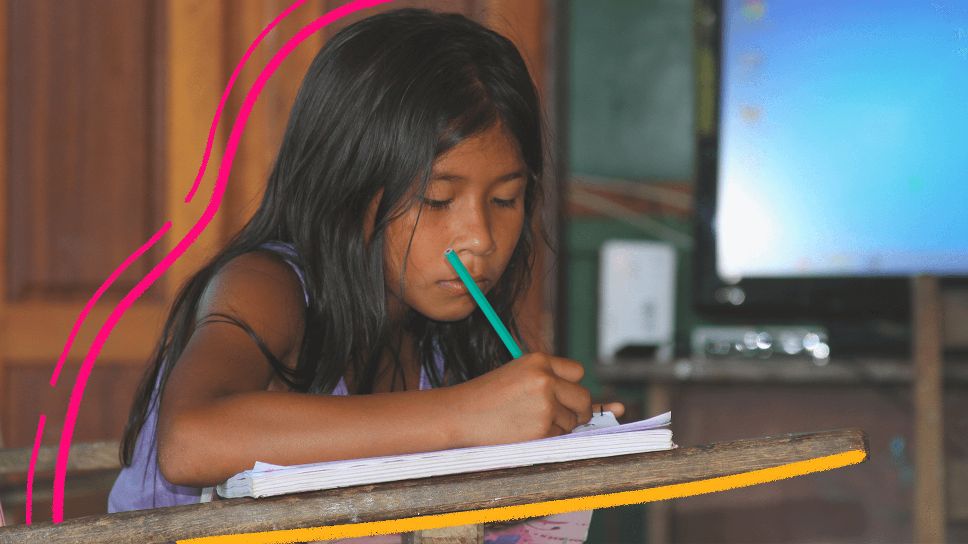 Imagem de capa para matéria sobre educação indígena no Pará mostra uma menina indígena sentada em uma carteira e escrevendo em um caderno, em uma sala de aula.