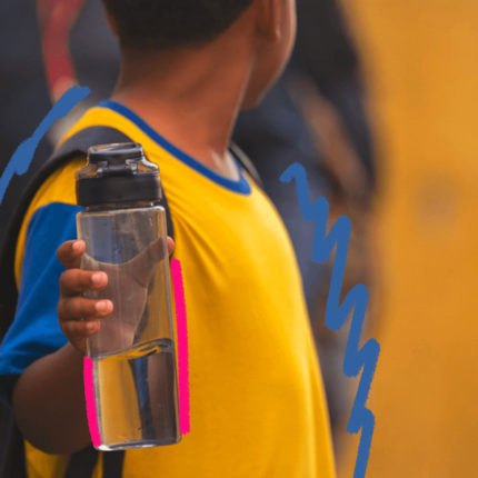 Altas temperaturas: Imagem de capa mostra um menino vestindo uniforme escolar e segurando uma garrafa de água.