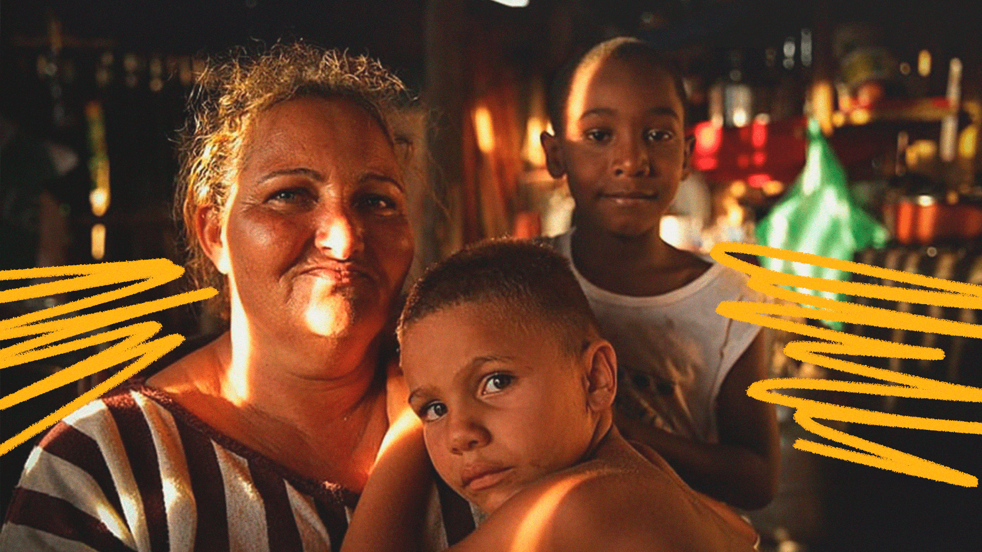 Imagem mostra uma família atingida pela tragédia de Brumadinho. Em close, uma mulher e duas crianças, dois meninos negros olhando para a câmera.