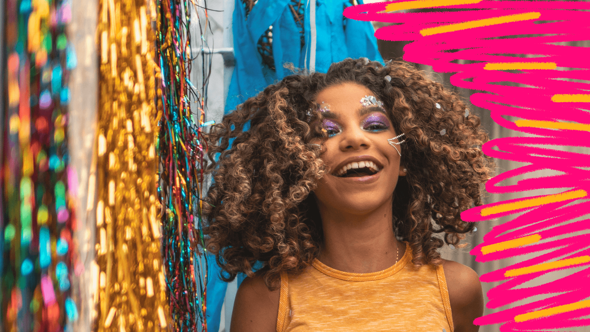 Carnaval com proteção: imagem de capa mostra uma menina negra de cabelhos cacheados sorrindo em meio a fantasias de carnaval.