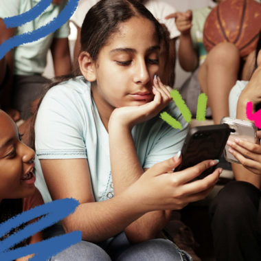 Privacidade na internert: Imagem mostra um grupo de adolescentes com três meninas sentadas olhando um celular.