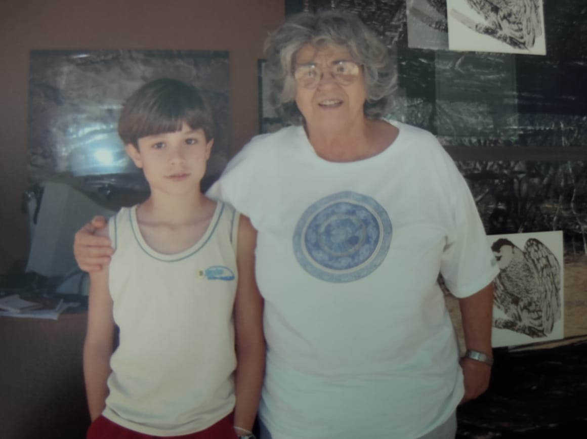 Imagem mostra a arqueóloga Niède Guidon ao lado de Julio, um menino branco de cabelos curtos.