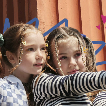 participação infantil - Imagem mostra duas meninas brancas com tranças no cabelo fazendo selfie com um celular.