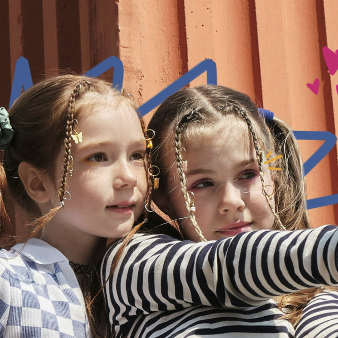 participação infantil - Imagem mostra duas meninas brancas com tranças no cabelo fazendo selfie com um celular.