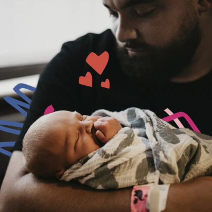 30 dias licença-paternidade: Imagem mostra um homem negro segurando um bebê no colo.