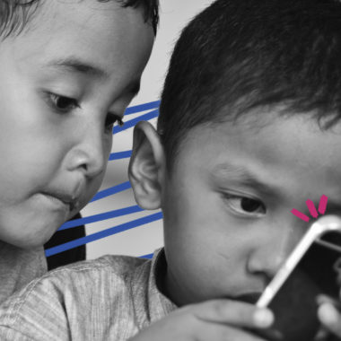 vídeos curtos: imagem de capa mostra duas crianças pequenas olhando um celular.