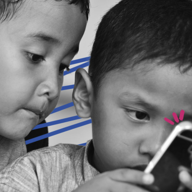 vídeos curtos: imagem de capa mostra duas crianças pequenas olhando um celular.