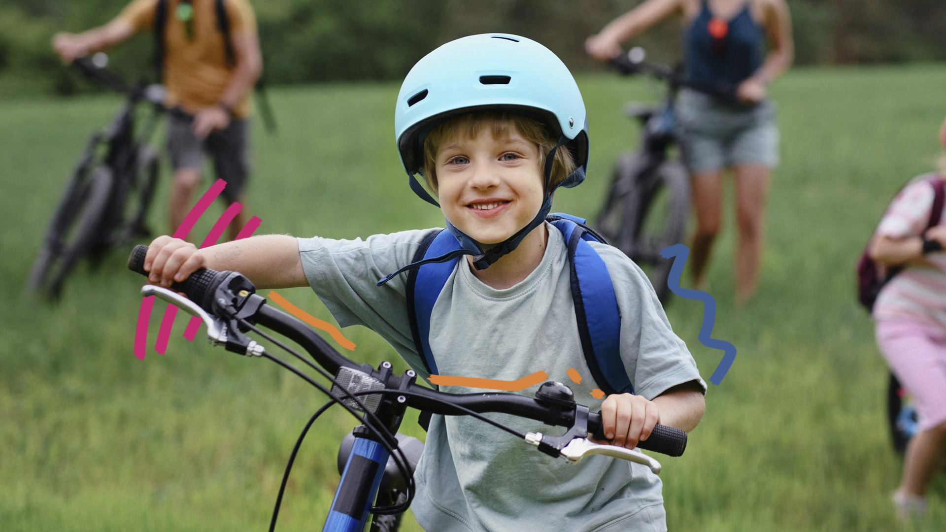 Foto de um menino de pele clara vestindo camiseta cinza e mochila de alças azuis nas costas. Ele está em pé ao lado da bicicleta e usa capacete, ambos azuis.
