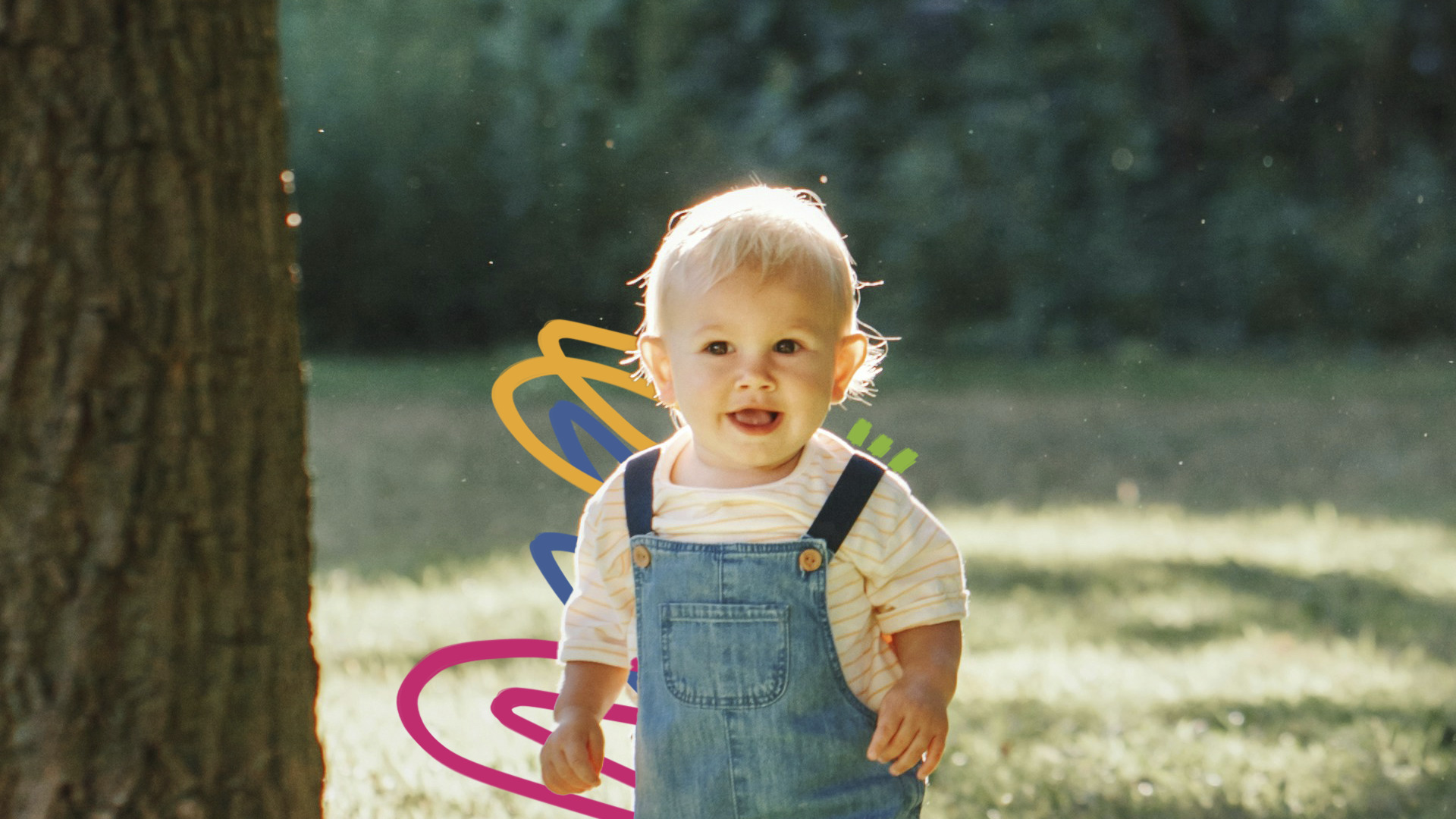 Um bebê de pele e cabelo claro está ao ar livre usando uma jardineira jeans e blusa branca.