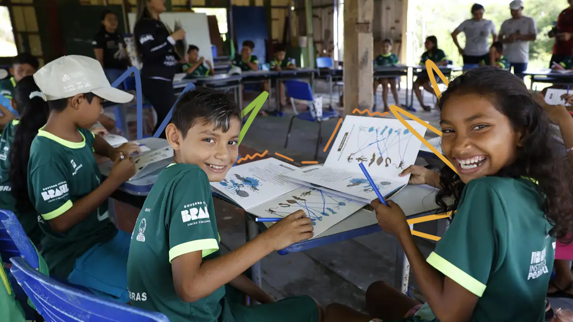 Três crianças de uniforme verde fazem um trabalho em grupo