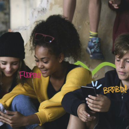 Três adolescentes - duas meninas e um menino - estão sentados no chão olhando para o celular. Na arte, palavras como flopou e brabo ilustram a linguagem dos adolescentes.